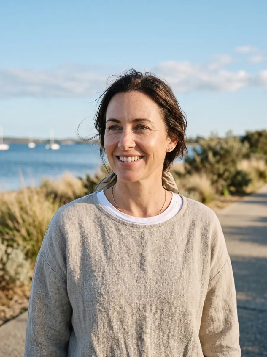 Smiling woman in her 40s outdoors with clear, comfortable eyes