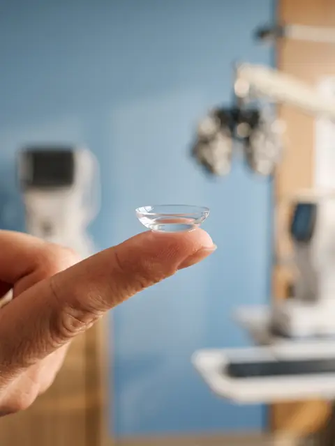 Scleral contact lens balanced on a fingertip